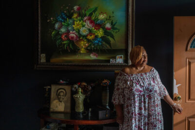 A woman stands in her home.